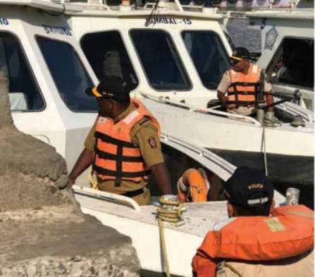 Marine police officers in MM life jackets boarding a patrol launch