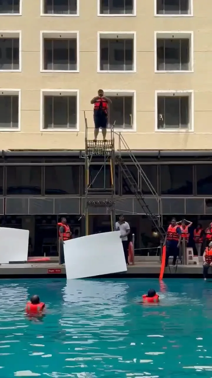 A wearer in an MM life jacket on the jump tower above the test pool